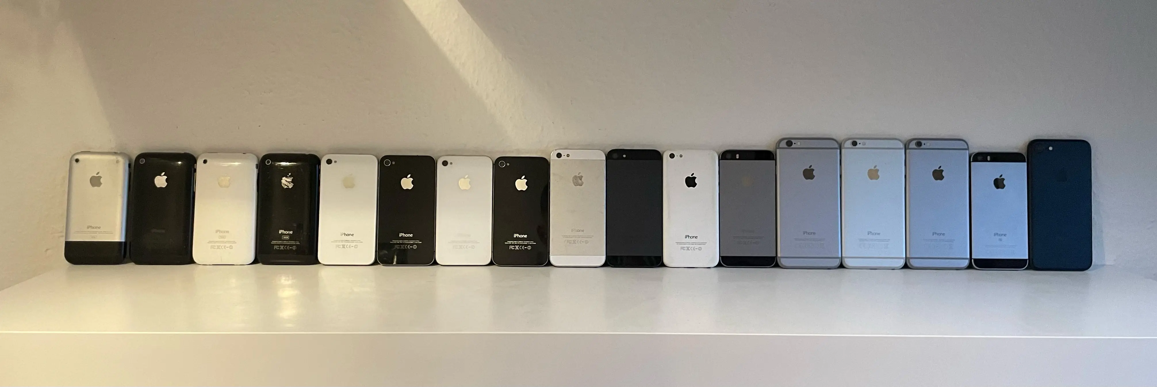 A picture showing an iPhone collection on a shelf.